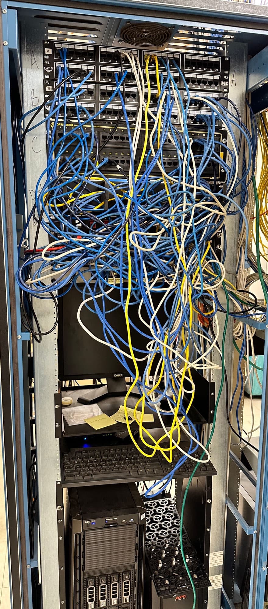 Client server rack before cleanup - a wall of tangled patch cables hiding the equipment