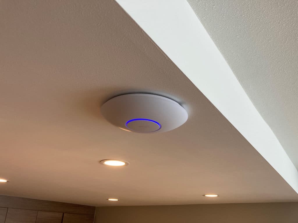 Low-profile wireless access point ceiling-mounted flush between recessed lights